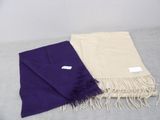 purple and cream scarfs with fringes on a bed