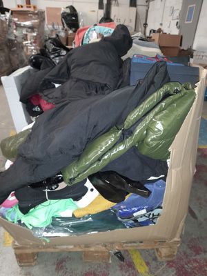 a pile of clothes sitting on top of a cart in a warehouse