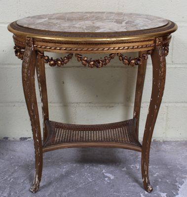 une petite table avec un plateau en marbre posée sur un sol en ciment