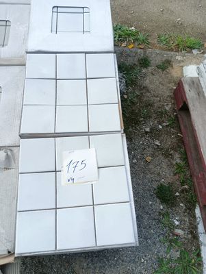 un tas de carreaux blancs posés par terre à côté d'un immeuble