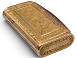 an antique gold cigarette case on a white background