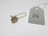 un gros plan sur une paire de boucles d'oreilles avec une étiquette de prix posée sur une table