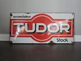 une enseigne rouge et blanche sur laquelle est inscrit « Tudor Stock »