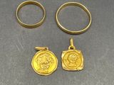 deux bagues en or et une pièce d'or posées sur une table