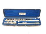 a flute in a blue case on a white surface