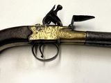 un pistolet accroché au mur, sur lequel est assis un homme