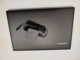 a laptop with a charger attached to the back of it