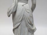 a white statue of a woman holding a flower in her hand