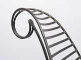 a metal chair that has a curved seat on it