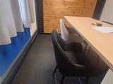 a desk and chair in a small room with a wooden wall