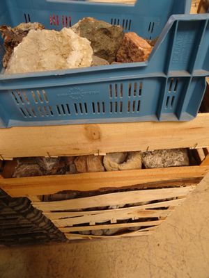 une caisse bleue remplie de cailloux, posée par terre