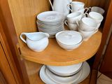 a corner cabinet with a lot of dishes on it