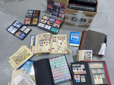 une boîte remplie de timbres et un livre par terre