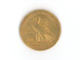 a gold coin with a bird on it on a white surface