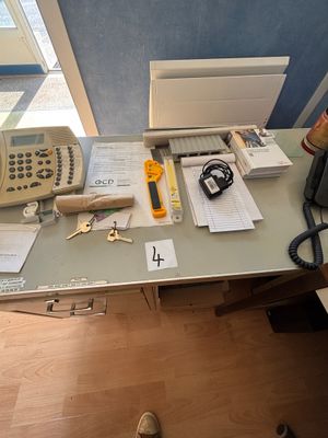 un bureau sur lequel se trouvent un téléphone et d'autres fournitures de bureau