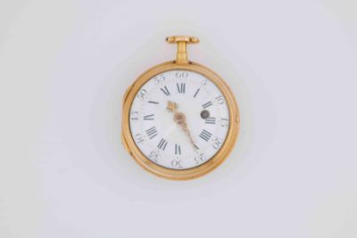 a gold pocket watch with roman numerals on the face