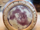 a purple and white vase sitting on a wooden table