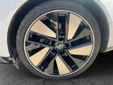 the wheel of a white car with black spokes on it