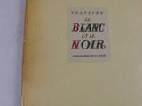 un vieux livre posé sur une table à côté d'une table blanche