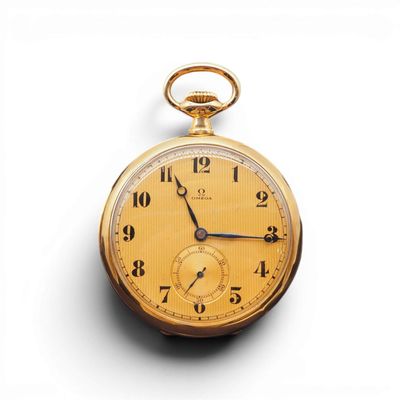 une vieille montre de poche en or posée sur une surface blanche, sur fond blanc