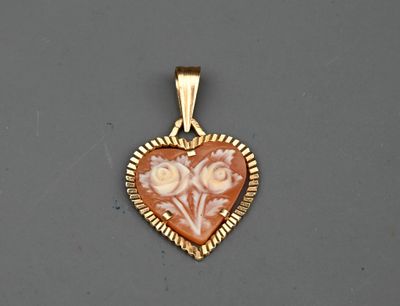 un gros plan d'un pendentif en forme de cœur posé sur une surface grise