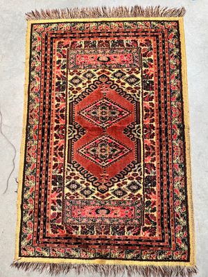 a red and black rug sitting on top of a white floor