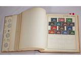 un livre ouvert avec des timbres, posé sur une table
