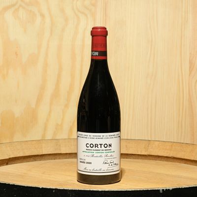 a bottle of wine sitting on top of a barrel
