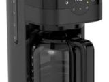 La cafetière est noire et contient une carafe en verre.