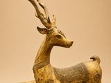 une image représentant une statue en bronze d'un cerf sur fond beige