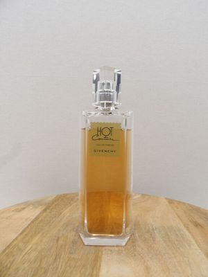 une photo d'un flacon de parfum posé sur une table en bois