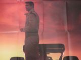 l'affiche du film « Le Film », sur laquelle figure un homme debout devant une voiture de course