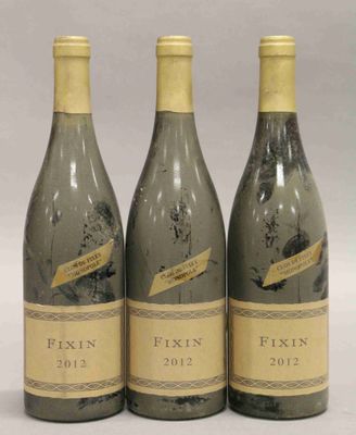 trois bouteilles de vin posées l'une à côté de l'autre sur une table