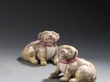 paire de figurines en céramique représentant deux chiens assis sur une surface grise
