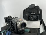 two cameras sitting on top of a bag on a table