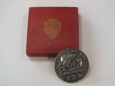 une pièce d'argent posée à côté d'une boîte rouge sur une table