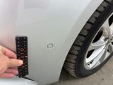 a hand that is holding a remote control in front of a car