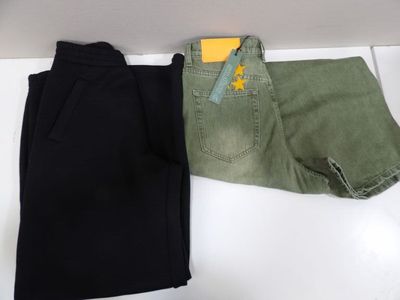 two pairs of black and green pants sitting on top of a white counter