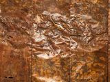 une photo en gros plan d'un morceau de métal posé sur une surface en bois