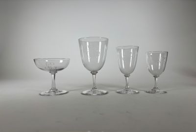 quatre verres à vin vides posés sur une table blanche