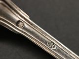 a close up of a silver spoon on a black surface