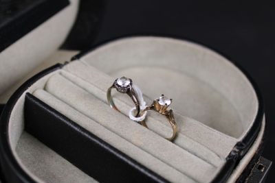 two wedding rings in a ring case on a black surface