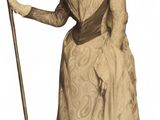 a woman in a dress and hat holding a cane