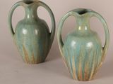 two green vases sitting next to each other on a table