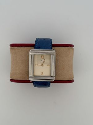 an image of a wrist watch with a blue band on a white surface