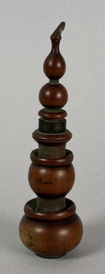 two wooden bowls stacked on top of each other with a bird on top of them