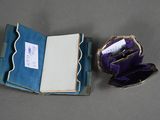 an open book sitting on top of a table next to a purple purse