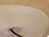 a white bowl with a black cord attached to it