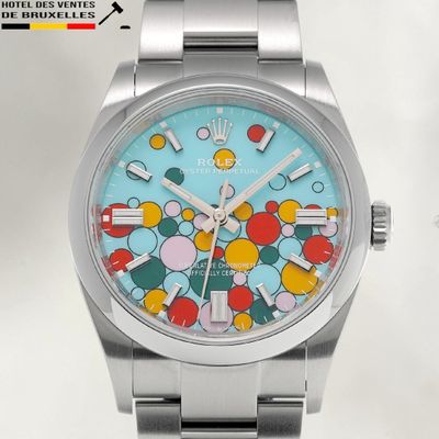 une montre en argent dont le cadran est orné d'un motif multicolore