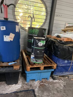 a blue barrel sitting on a pallet next to a blue barrel